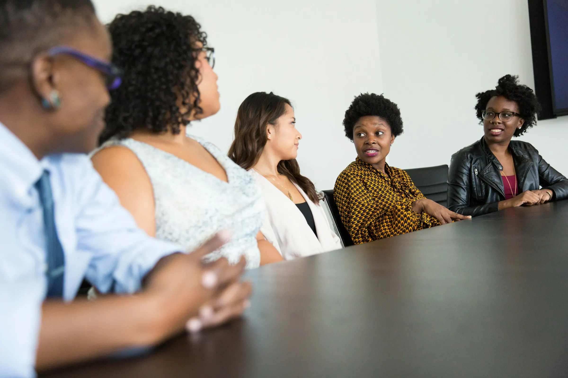 Pessoas conversam em volta de uma mesa de reunião.